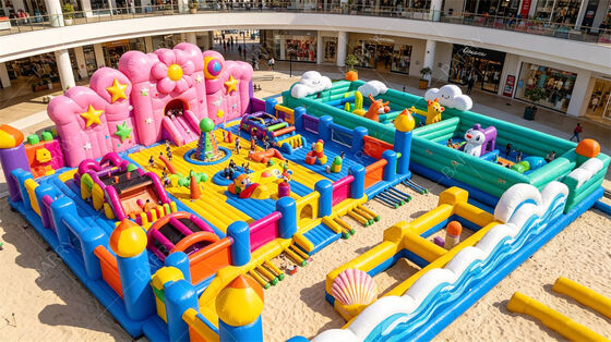 Ciudad de la diversión hinchable con temática de pastel gigante. Parque todo en uno con tobogán de flores, zonas de juego de animales y obstáculos interactivos. PVC comercial para centros comerciales interiores y festivales al aire libre.